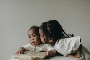Older sibling kissing a baby, representing family healthcare and wellbeing supported by DirectDoc telehealth